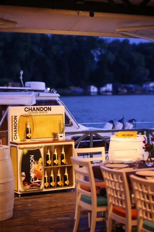 Champagne Station uz vodu, čamac u pozadini
